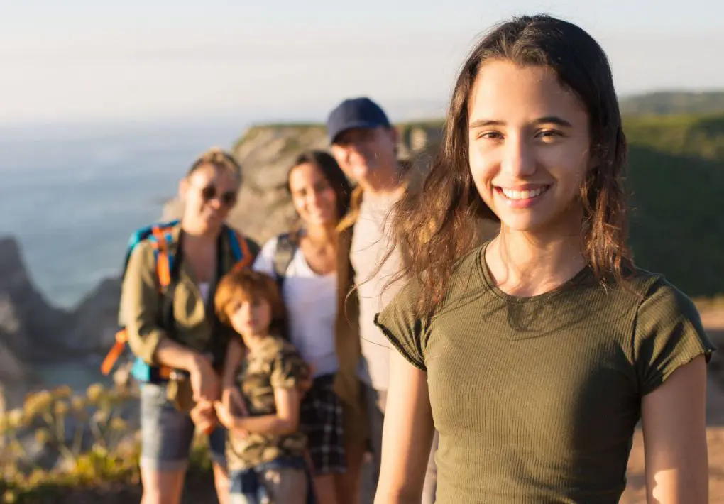 Teen girl hiking with family as part of cocaine addiction treatment Teen girl hiking with family as part of cocaine addiction treatment