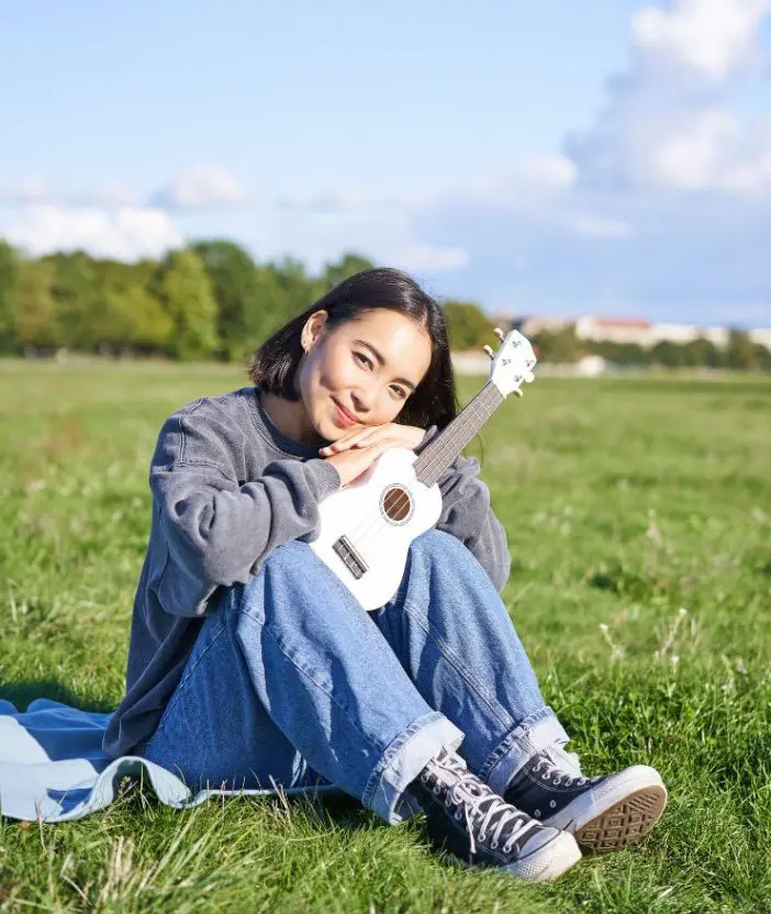 A happy woman holding a ukulele after recovering from cannabis addiction A happy woman holding a ukulele after recovering from cannabis addiction