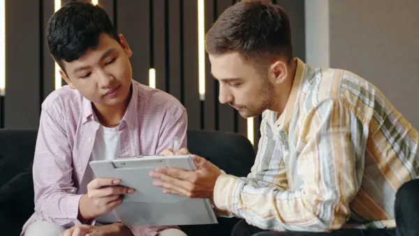 A father and son reviewing information on preparing a teenager for a partial hospitalization program