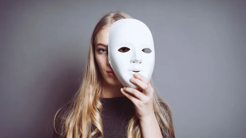 Teen holding a mask to represent emotional numbness linked to Adderall use