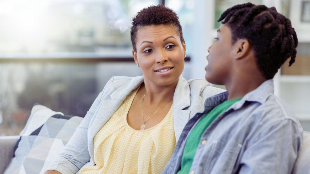 Parent talking with a teen boy about emotional concerns.
